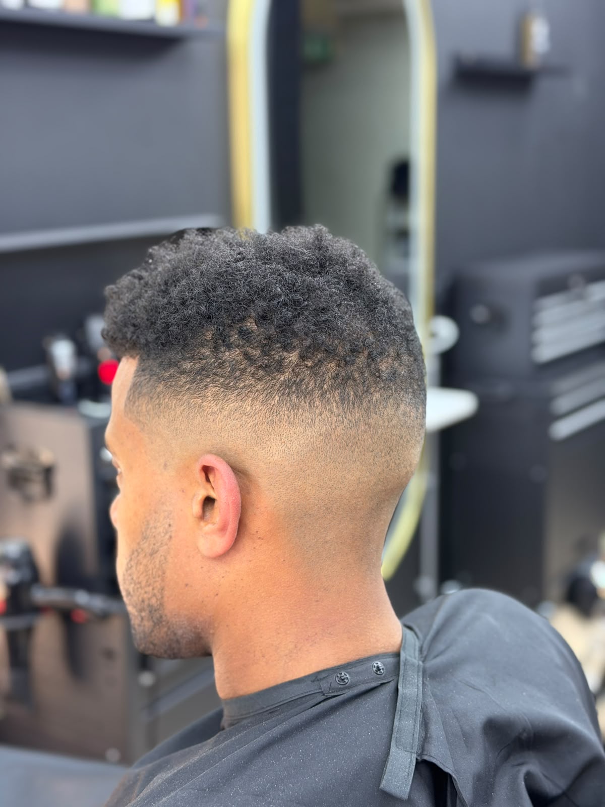 Curly top met strakke high fade
